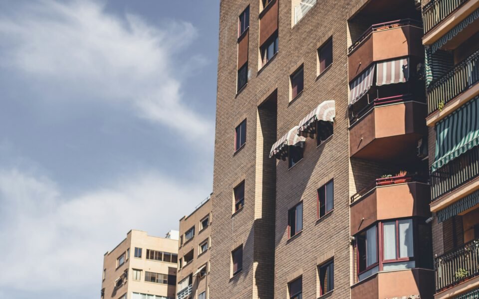 Bloques de viviendas de ladrillo con balcones y toldos en una ciudad española