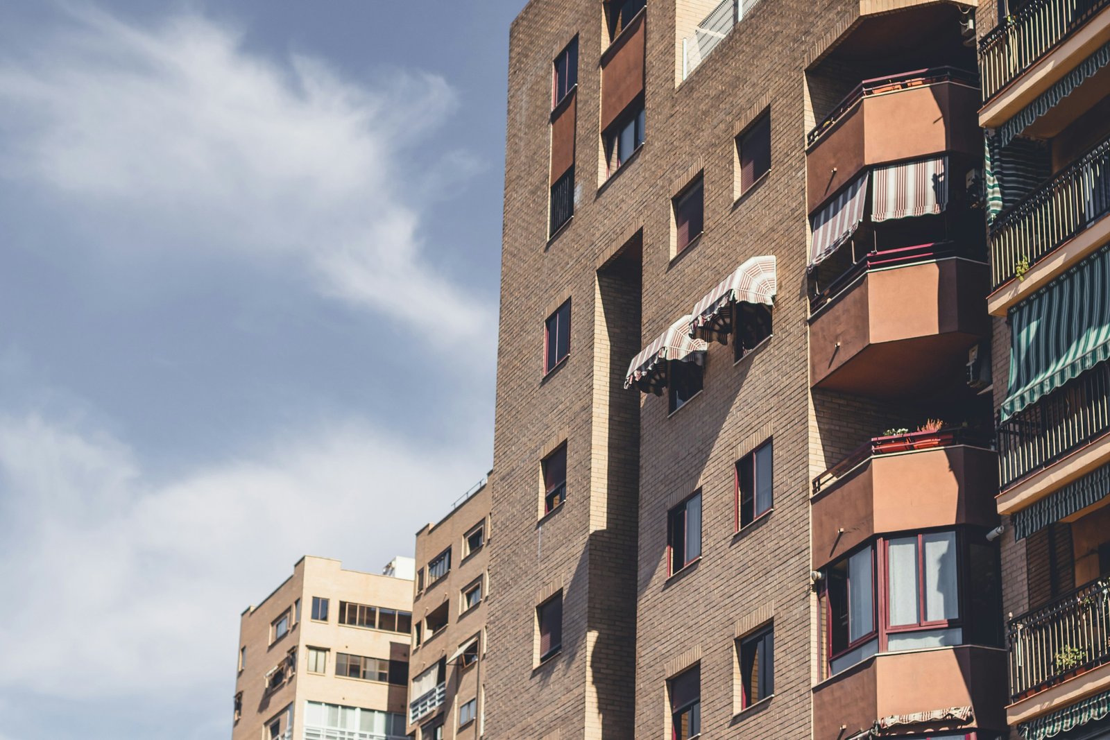 Bloques de viviendas de ladrillo con balcones y toldos en una ciudad española