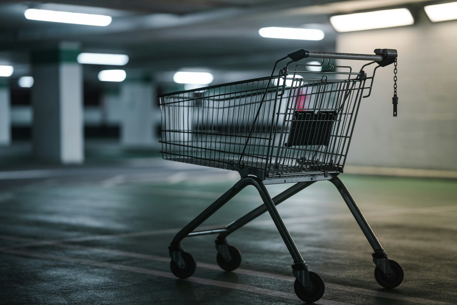 Carro de la compra metálico vacío en un aparcamiento cubierto