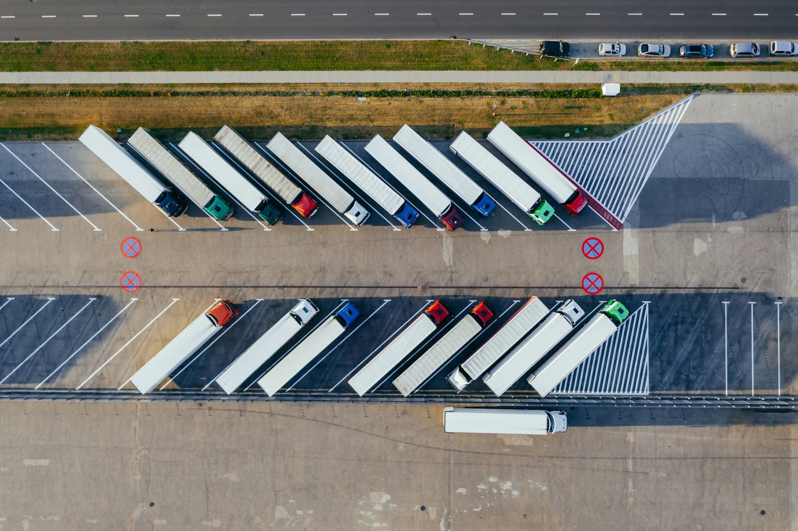 Vista cenital de camiones aparcados en batería junto a una carretera