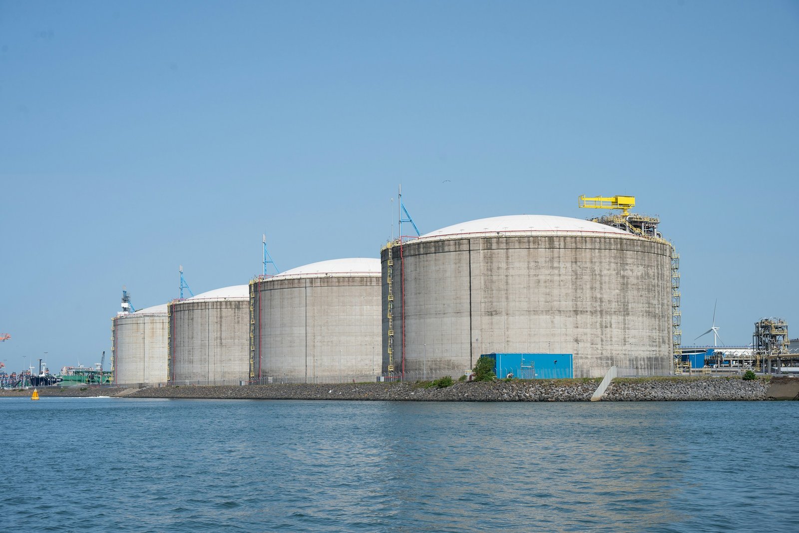 Tanques de gas natural licuado en una terminal portuaria junto al mar