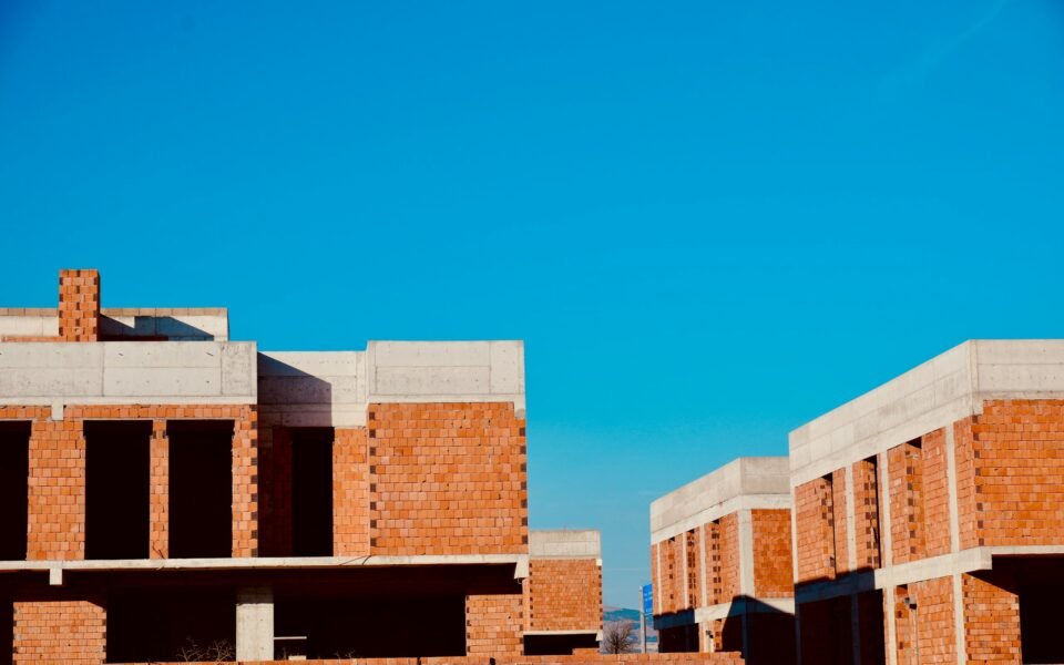 Viviendas en construcción de ladrillo y hormigón con cerros secos al fondo