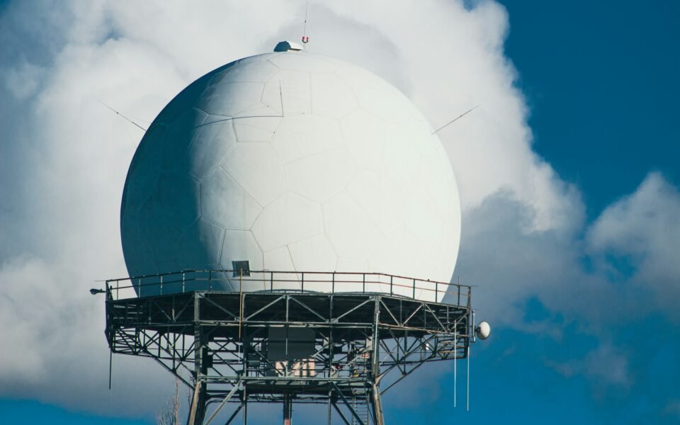 Radomo blanco de radar sobre una plataforma metálica entre nubes