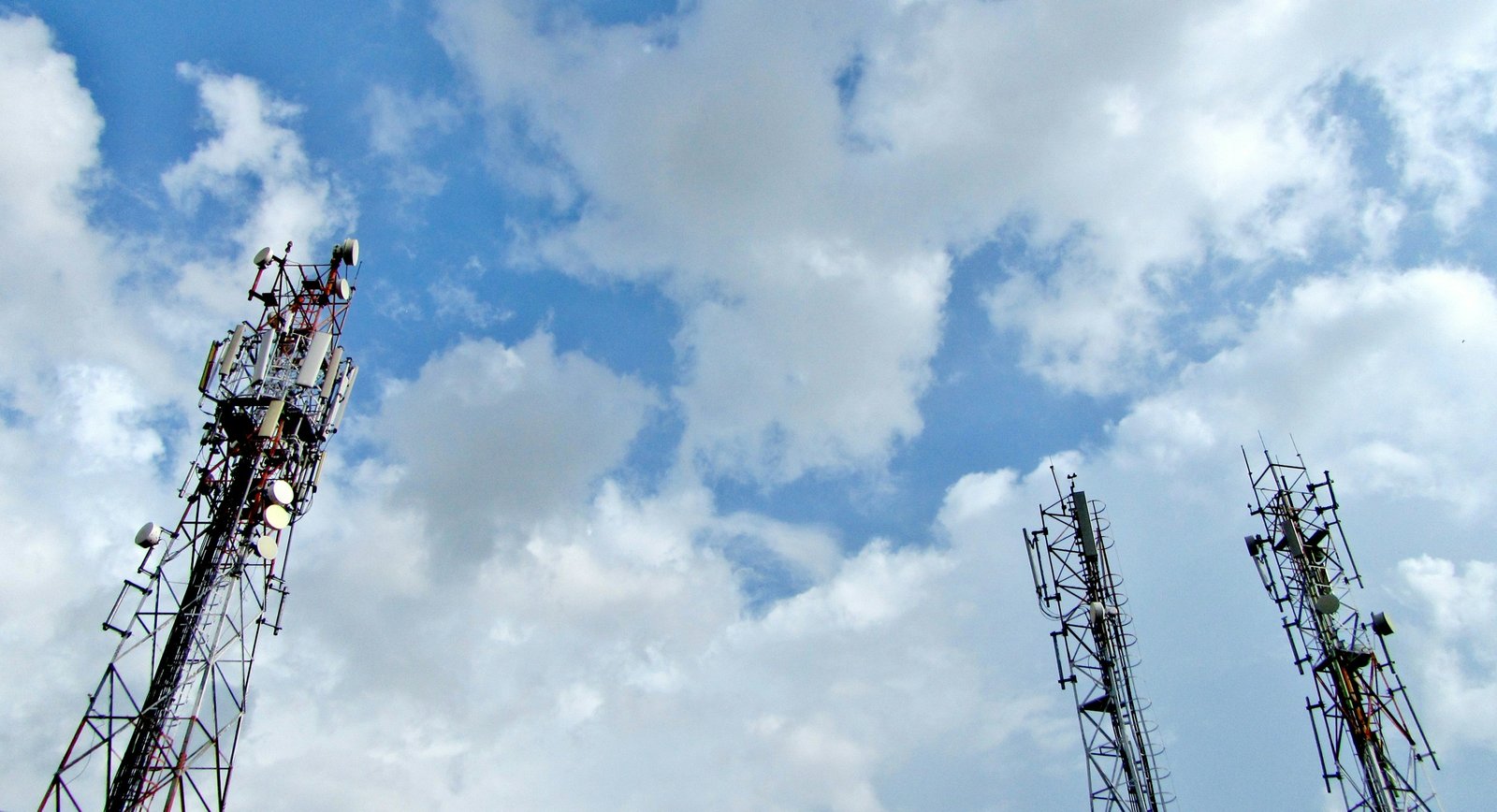 Torres de telecomunicaciones con antenas bajo un cielo con nubes