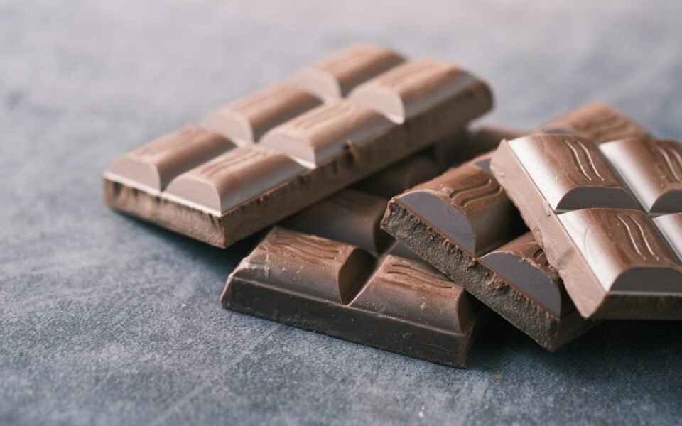 Onzas de chocolate negro apiladas sobre una superficie gris