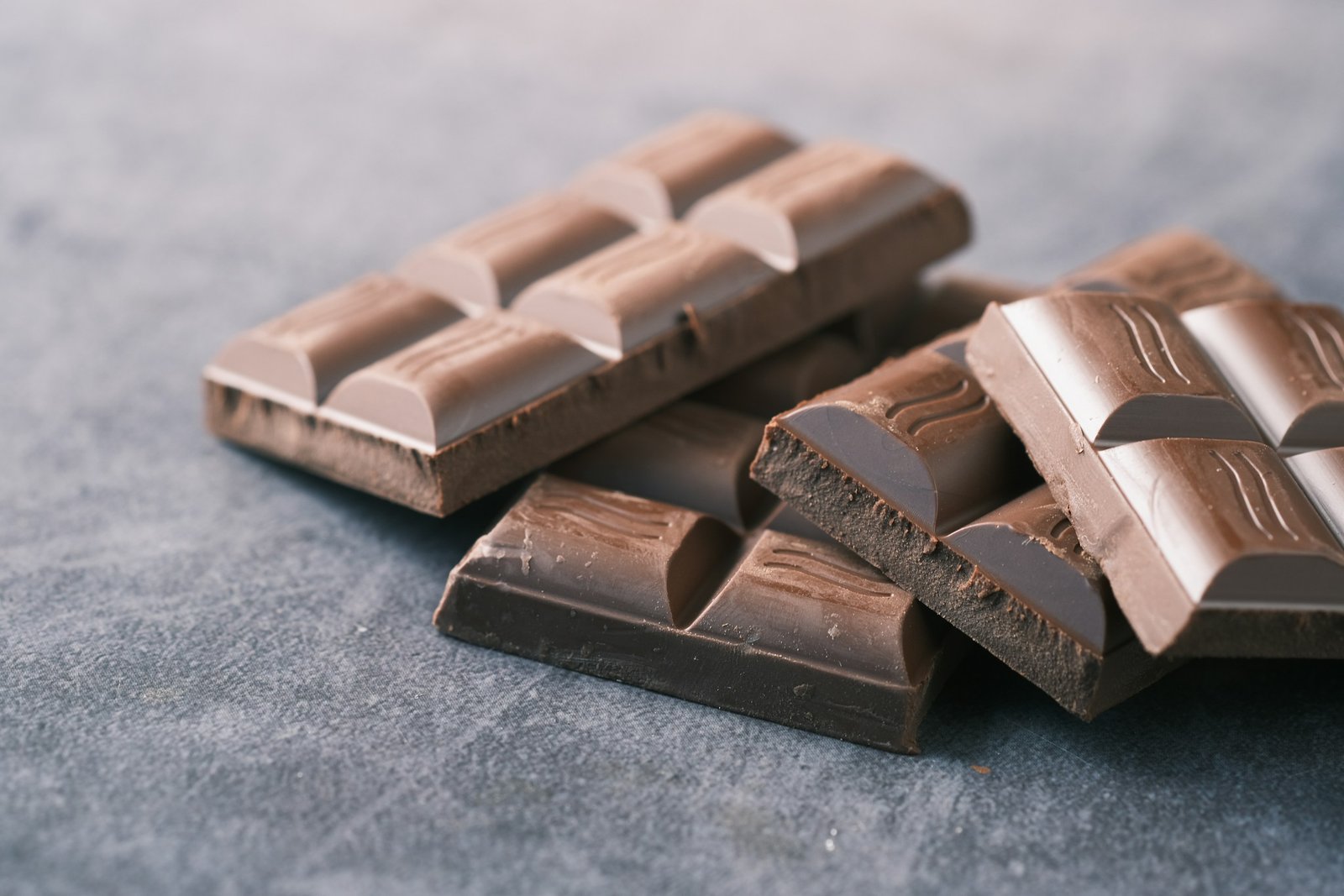 Onzas de chocolate negro apiladas sobre una superficie gris