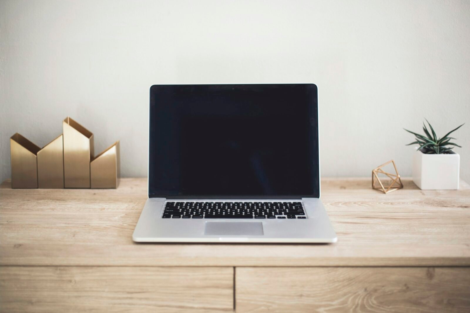 Portátil con la pantalla apagada sobre una mesa de madera