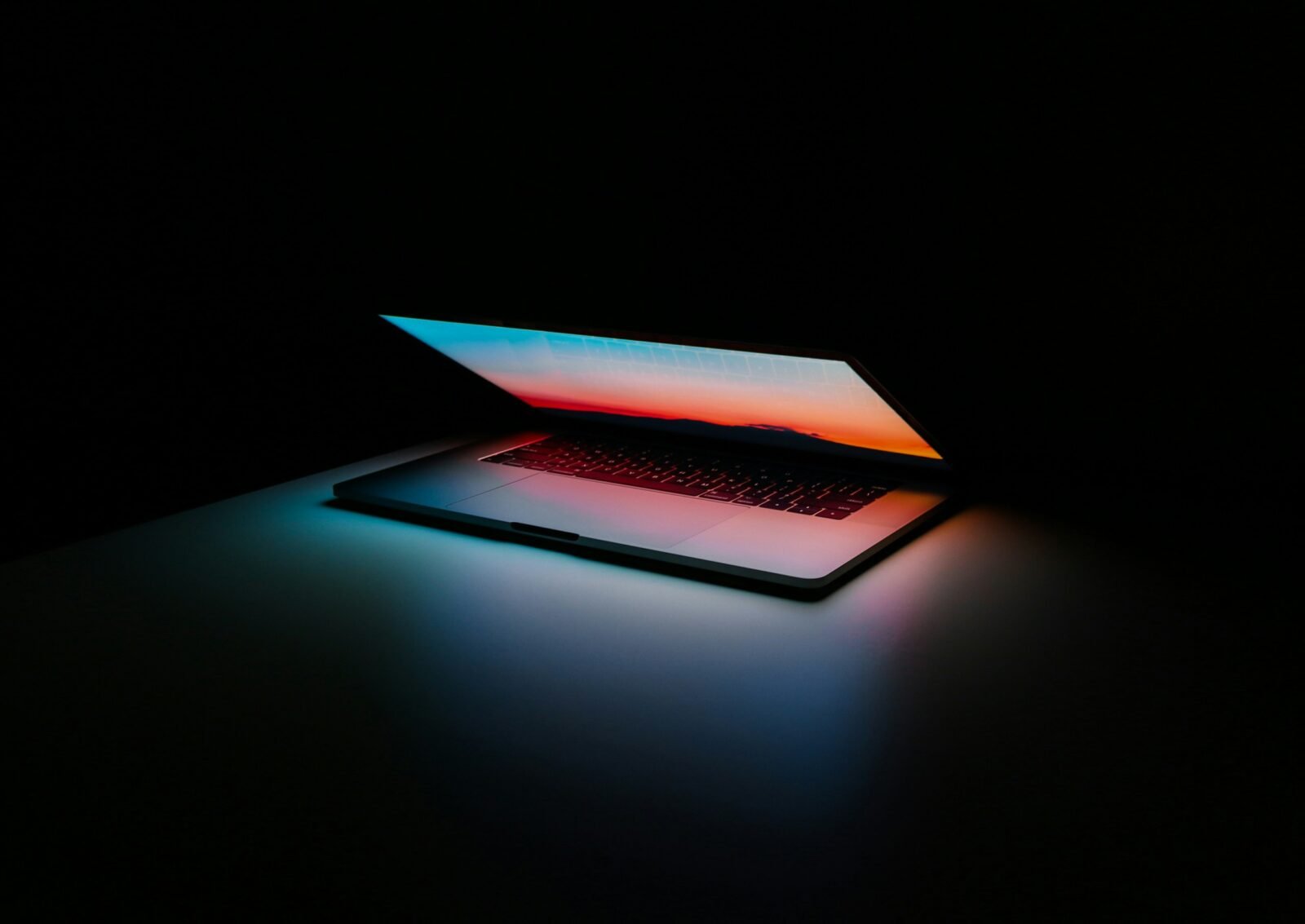 Ordenador portátil entreabierto con la pantalla iluminada