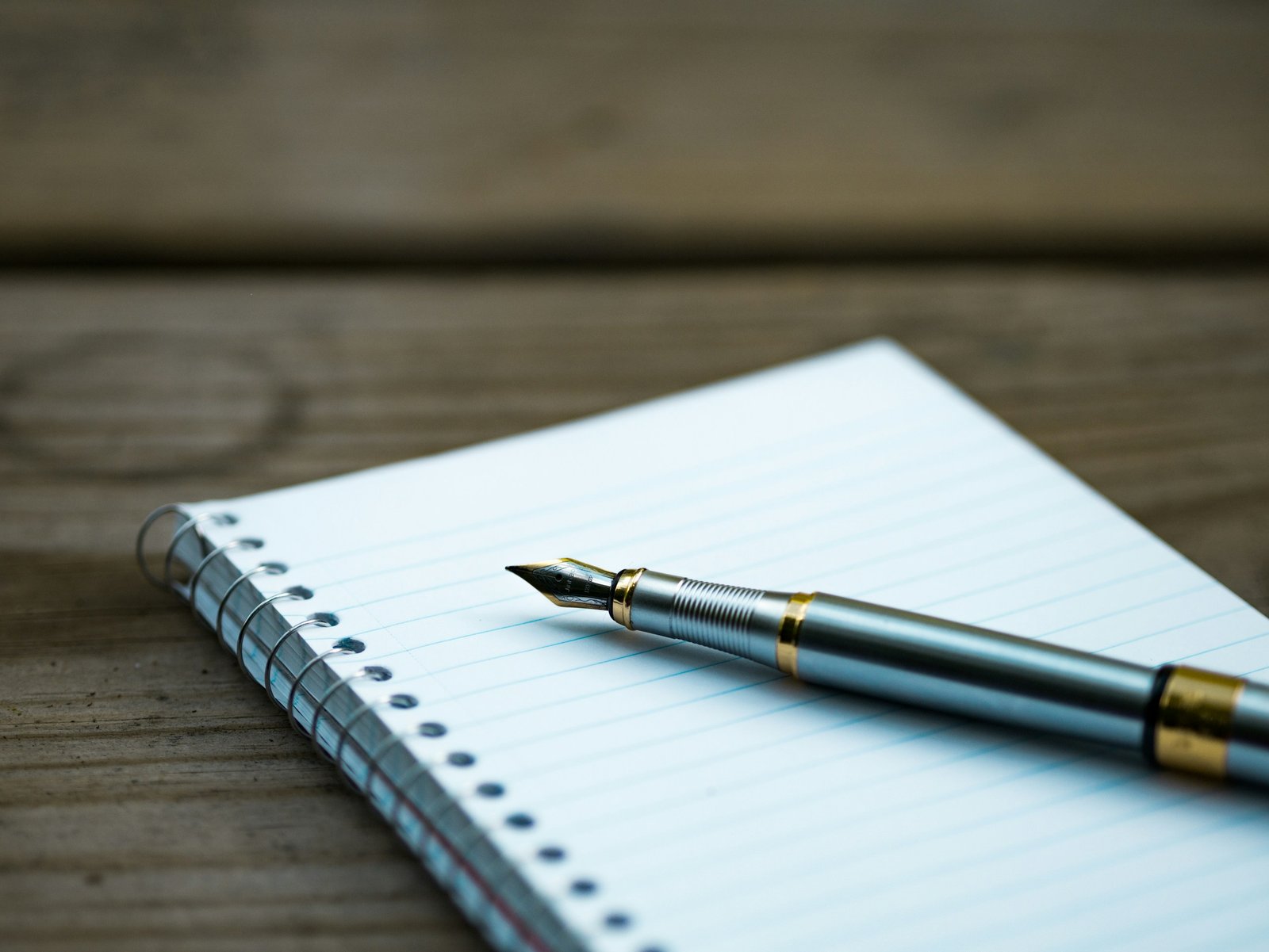 Pluma estilográfica sobre un cuaderno de espiral en blanco