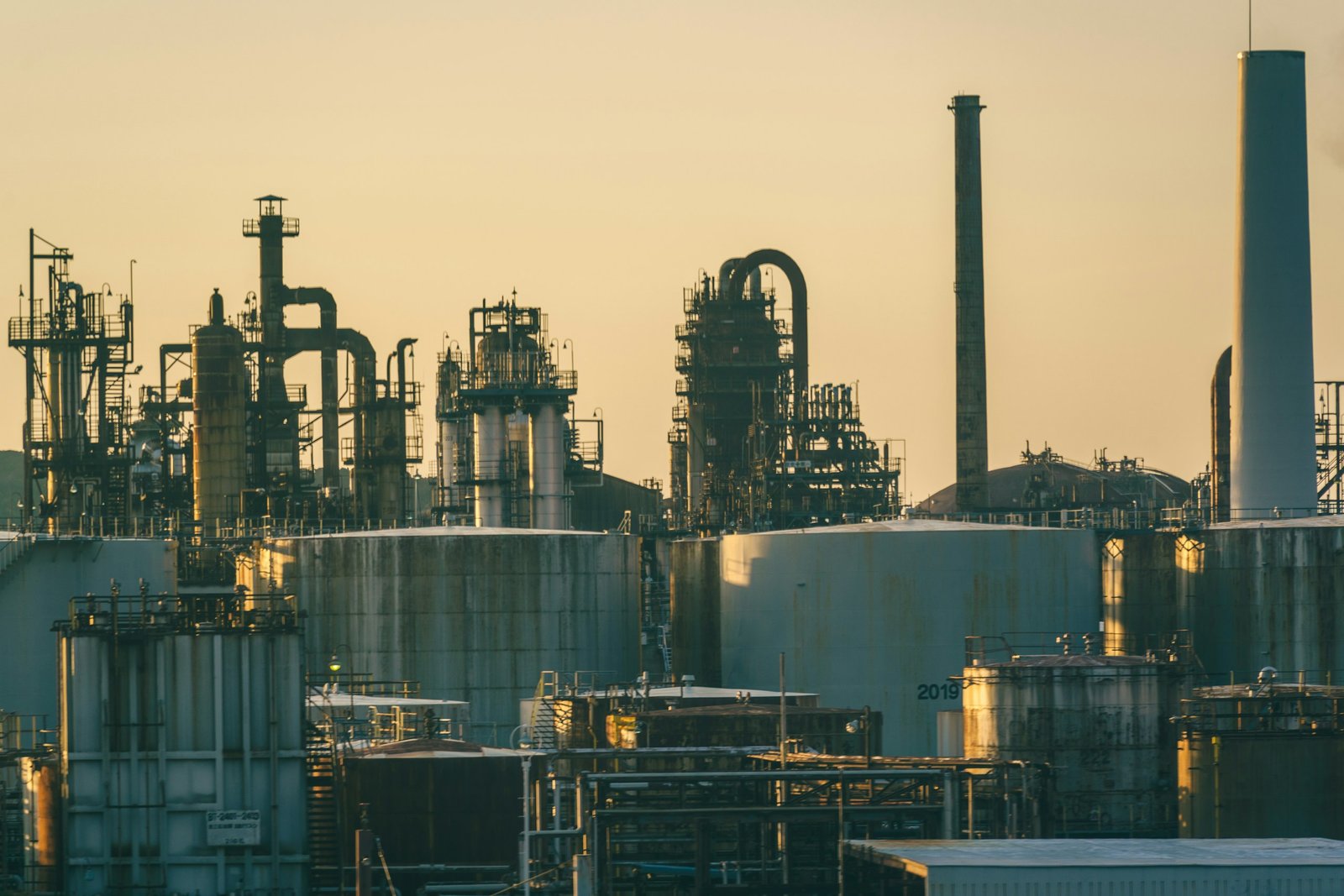 Torres de proceso y depósitos de una refinería al atardecer