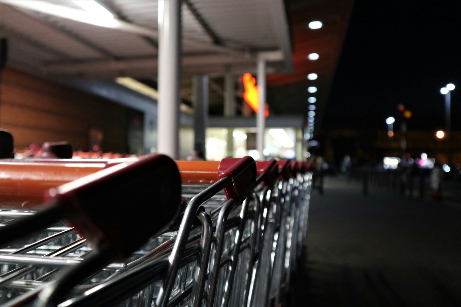 Hilera de carros de la compra junto a un supermercado de noche