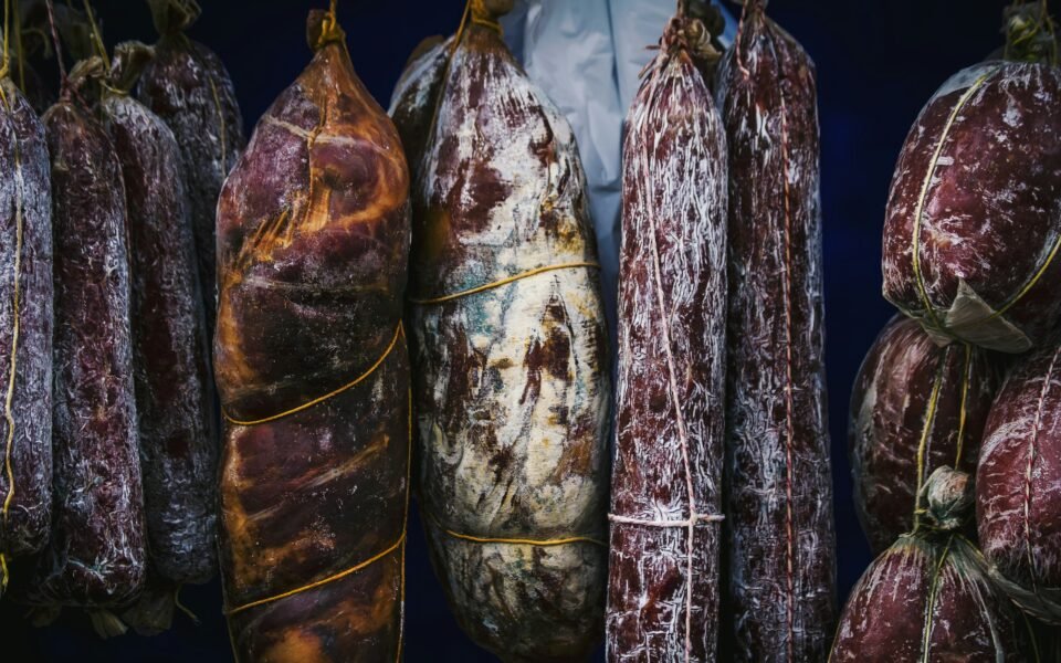 Embutidos curados colgados con cuerda, cubiertos de moho blanco